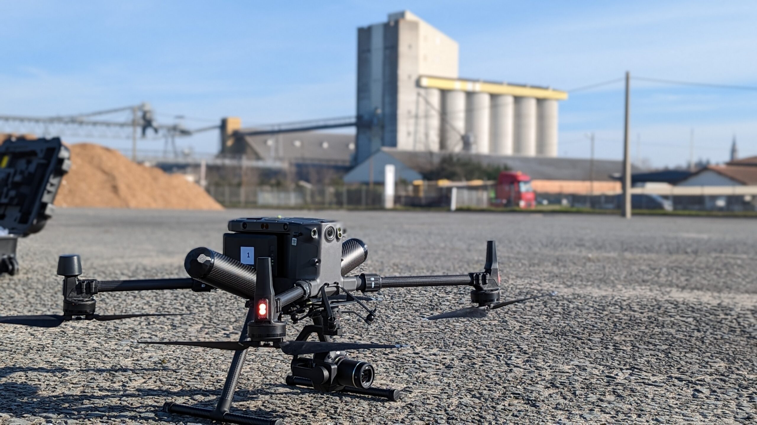 Drone d'inspection Drones Solutions posé devant un site industriel
